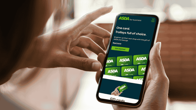 a woman holding a phone and on the phone is asda mobile